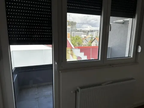 Pogled kroz prozor sa roletnama i radijatorom ispod. - image 6