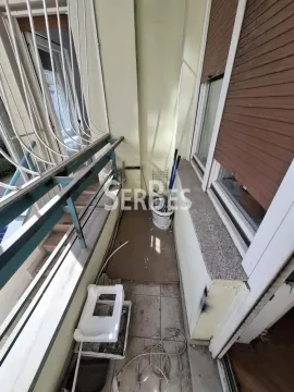 Manji nenamešten balkon sa metalnom ogradom i prozorima sa spoljnim roletnama. - image 2