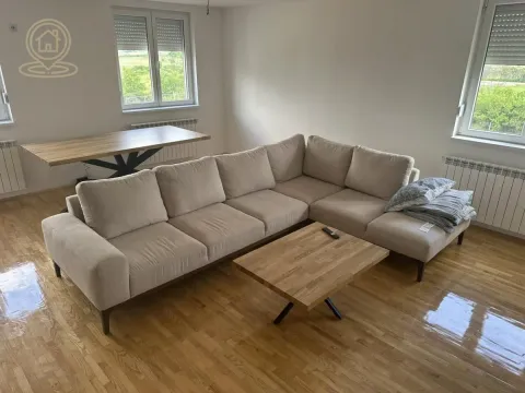 Living room with a sectional sofa, wooden coffee table, and dining table. - image 2