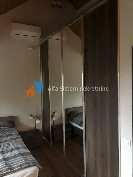 Bedroom with a large built-in mirrored wardrobe and a double bed.