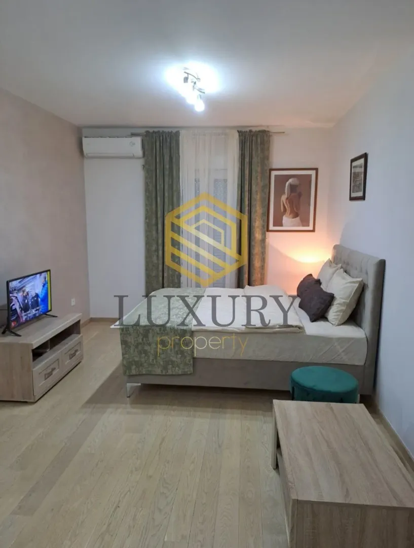 Furnished bedroom with a double bed, TV unit, and air conditioning.