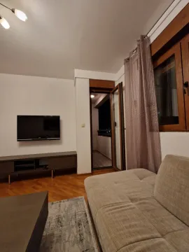 Dnevna soba sa televizorom montiranim na zid i izlazom na balkon. - image 9
