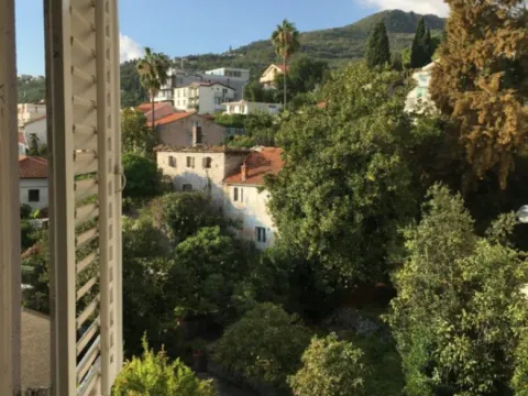 Pogled sa prozora na okolno zelenilo, kuće i brda u daljini. - image 3