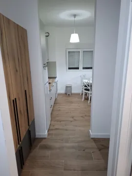View from the hallway into a furnished kitchen with a dining area. - image 5