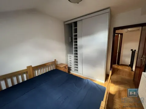 Spavaća soba sa bračnim krevetom, velikim garderoberom i drvenim podom. - image 13