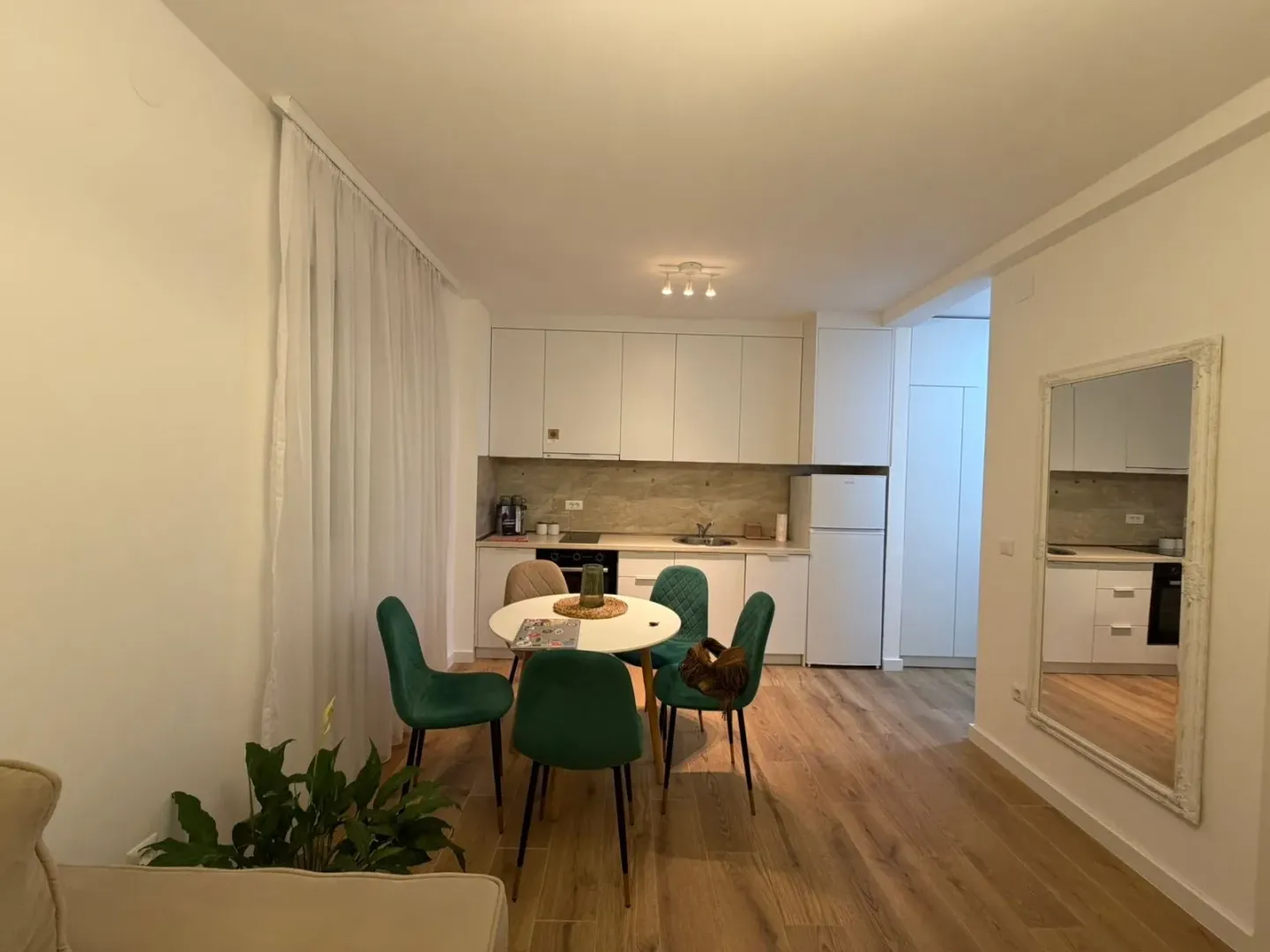 Dining area with a modern white kitchen.