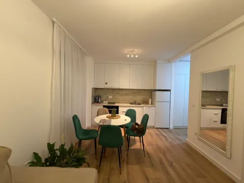 Dining area with a modern white kitchen. - image 2