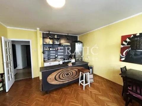 Small kitchen with a breakfast bar connected to the dining area and hardwood flooring. - image 15