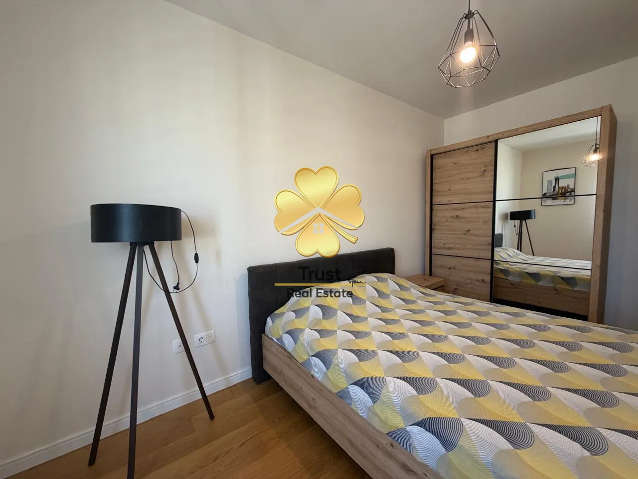 Furnished bedroom with a double bed, wardrobe, and floor lamp.