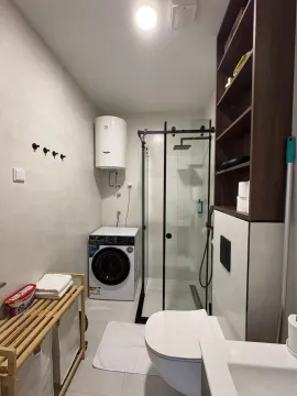 Modern bathroom with a walk-in shower, washing machine, and sanitary fixtures. - image 8