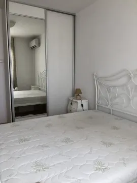 Simple bedroom with a white bed and a built-in wardrobe with a mirror. - image 24
