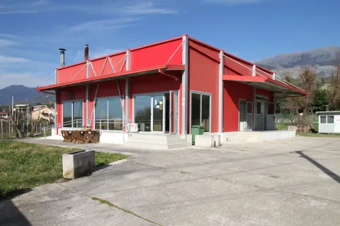 Exterior view of a modern prefabricated building with a red facade. - image 6