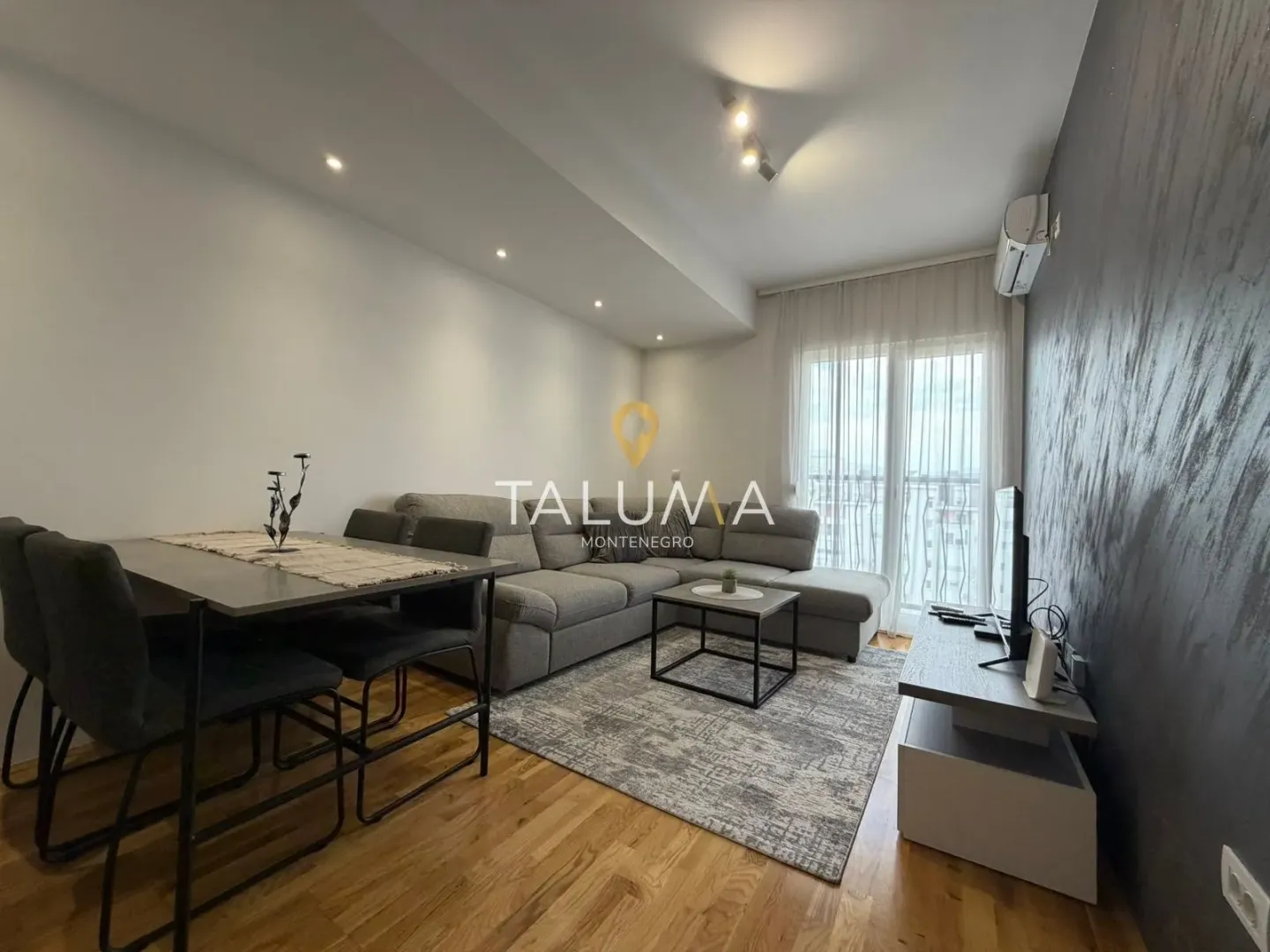 Living room with a sofa, dining table, and access to the terrace.