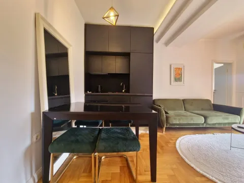 Living room with a dining area and a modern black kitchen in the background. - image 4