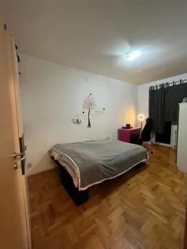 Spavaća soba sa bračnim krevetom, radnim stolom i drvenim parketom. - image 9