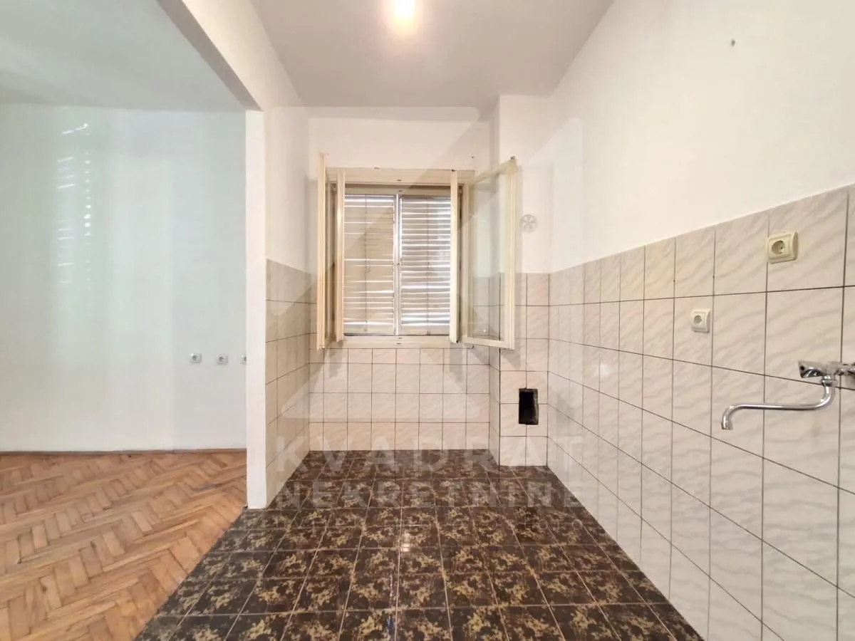 Empty kitchen with tiles and a window.