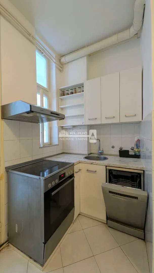 Small white kitchen with a stove, sink, and dishwasher.