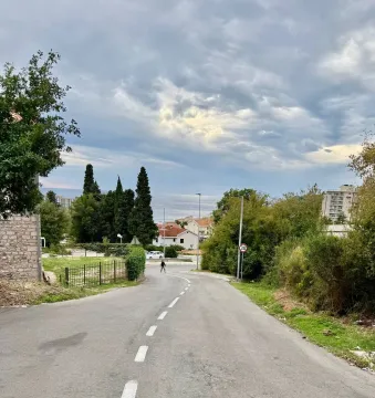 Pogled na ulicu i okolinu sa zelenilom i morem u pozadini. - image 6