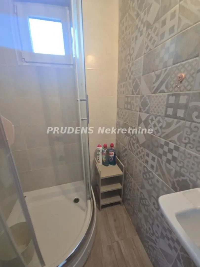 Bathroom with a shower cabin and decorative wall tiles.