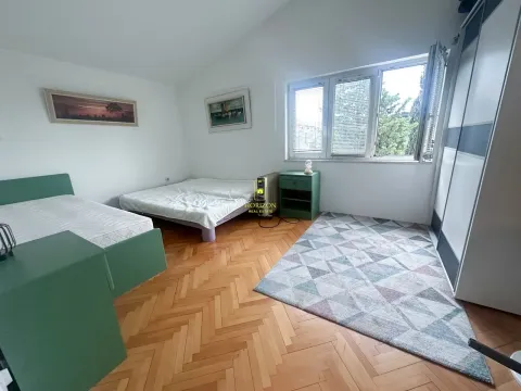 Prostrana spavaća soba sa dva kreveta, parketom i velikim prozorom. - image 9