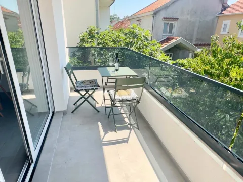Small bright balcony with seating furniture and a view of the surroundings. - image 10