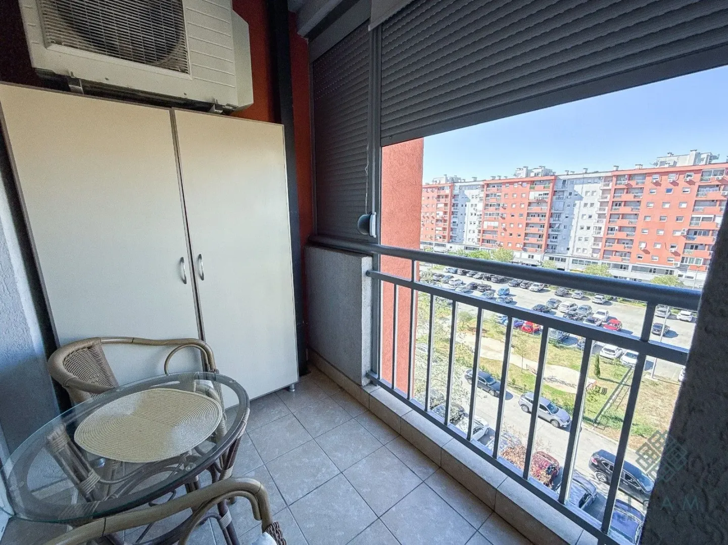 Covered balcony with patio furniture and a view of the neighborhood.