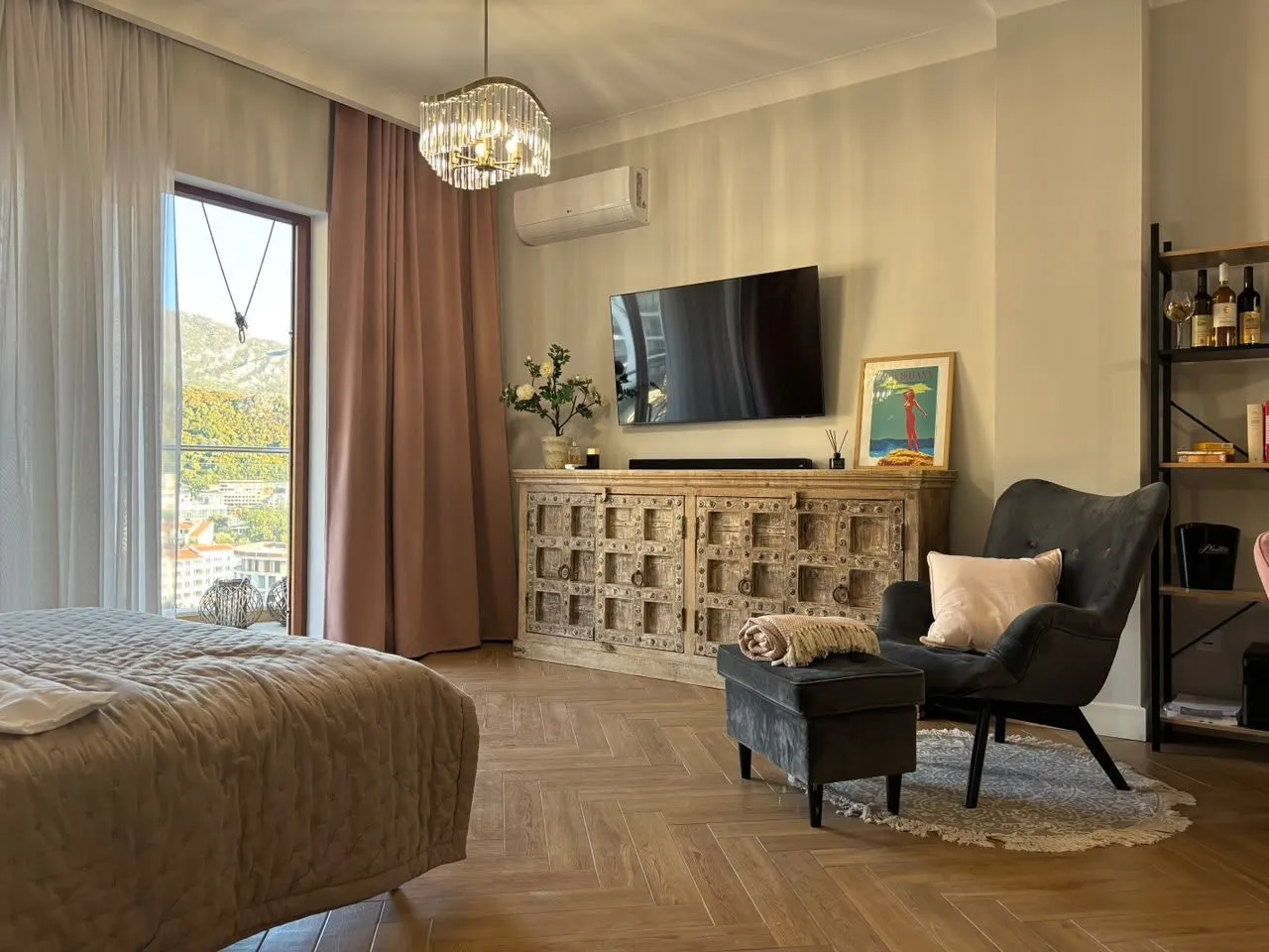 Moderna spavaća soba sa bračnim krevetom, foteljom i izlazom na terasu.