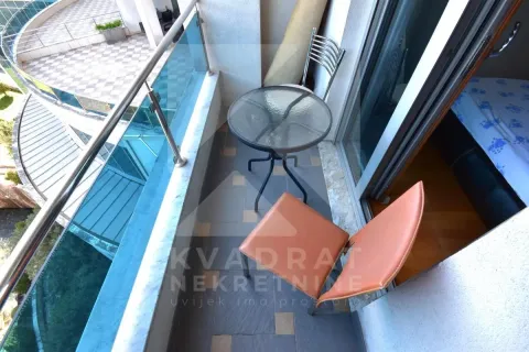 Small furnished balcony with a table and chairs. - image 11