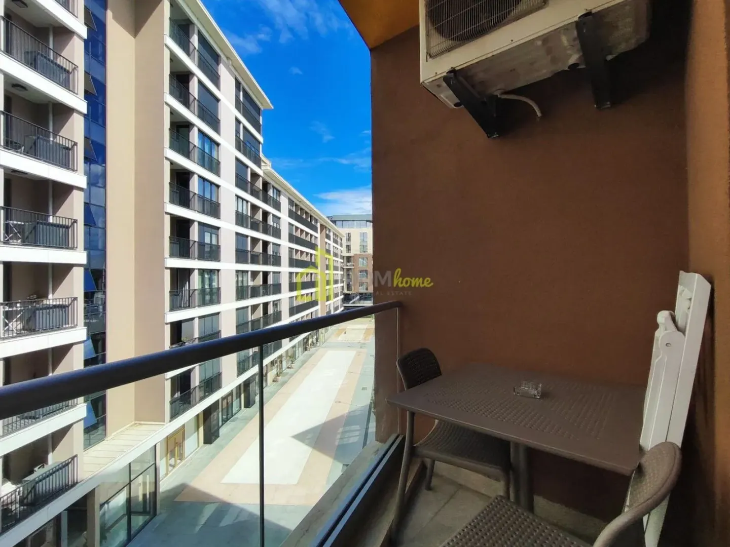Namješten balkon sa garniturom za sjedenje i pogledom na naselje.