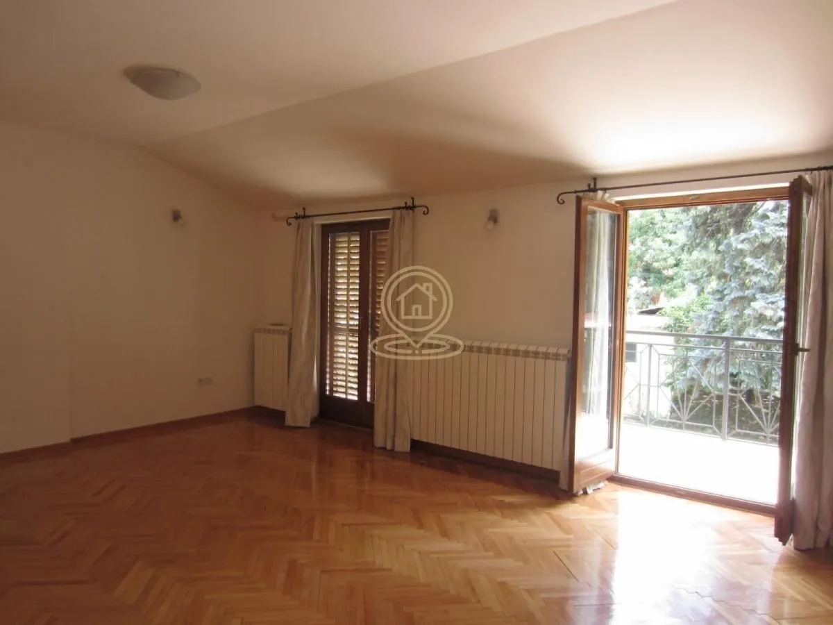 Empty room with hardwood parquet flooring and access to the terrace.