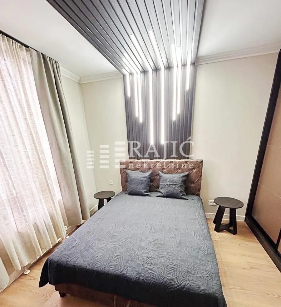 Furnished bedroom with a double bed and decorative wall panels.