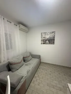 Living room with a grey sofa, air conditioning unit, and wall art. - image 3