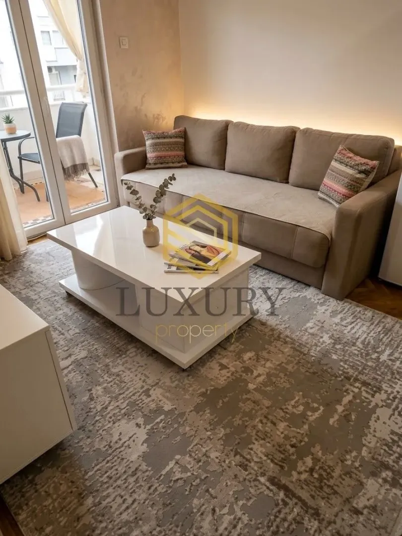 Living room with a sofa, coffee table, and balcony access.