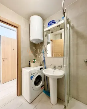 Bathroom equipped with a washbasin, washing machine, shower cabin, and water heater. - image 7