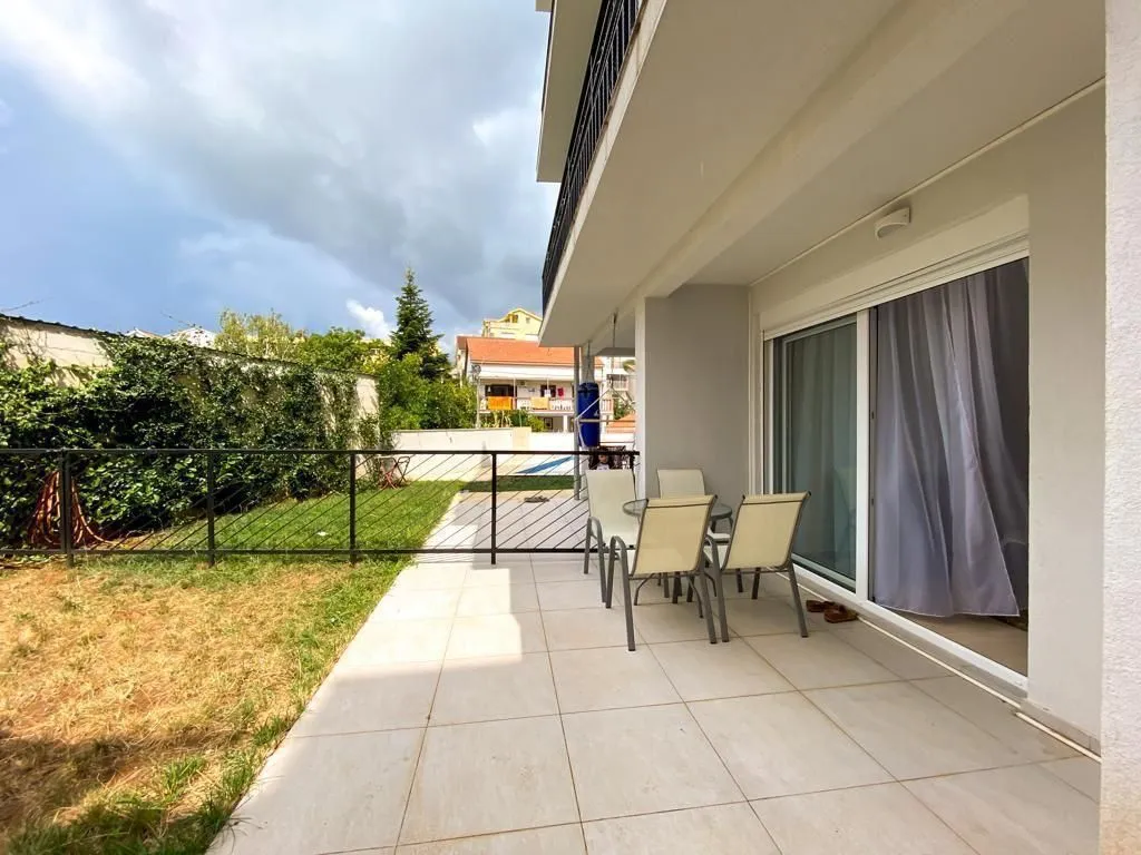 Covered terrace with outdoor seating furniture and access to the yard.