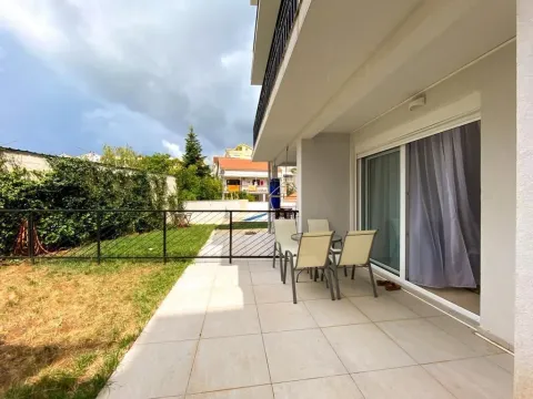 Covered terrace with outdoor seating furniture and access to the yard. - image 14