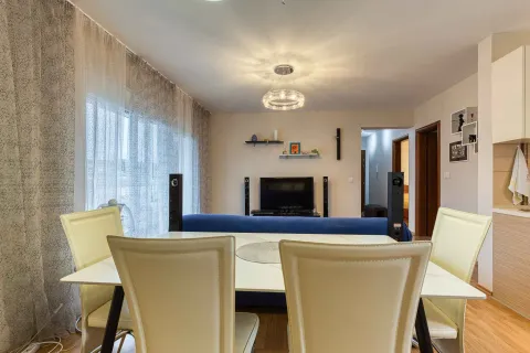 Living room with a dining table and chairs in the foreground. - image 6