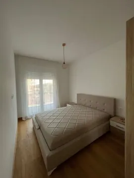 Bright bedroom with a double bed, nightstand, and balcony doors. - image 4