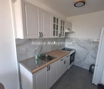 Manja bela kuhinja sa drvenom radnom pločom i šporetom. - image 8
