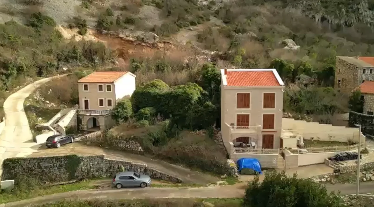 Pogled iz vazduha na kamene kuće smještene u brdovitom krajoliku.