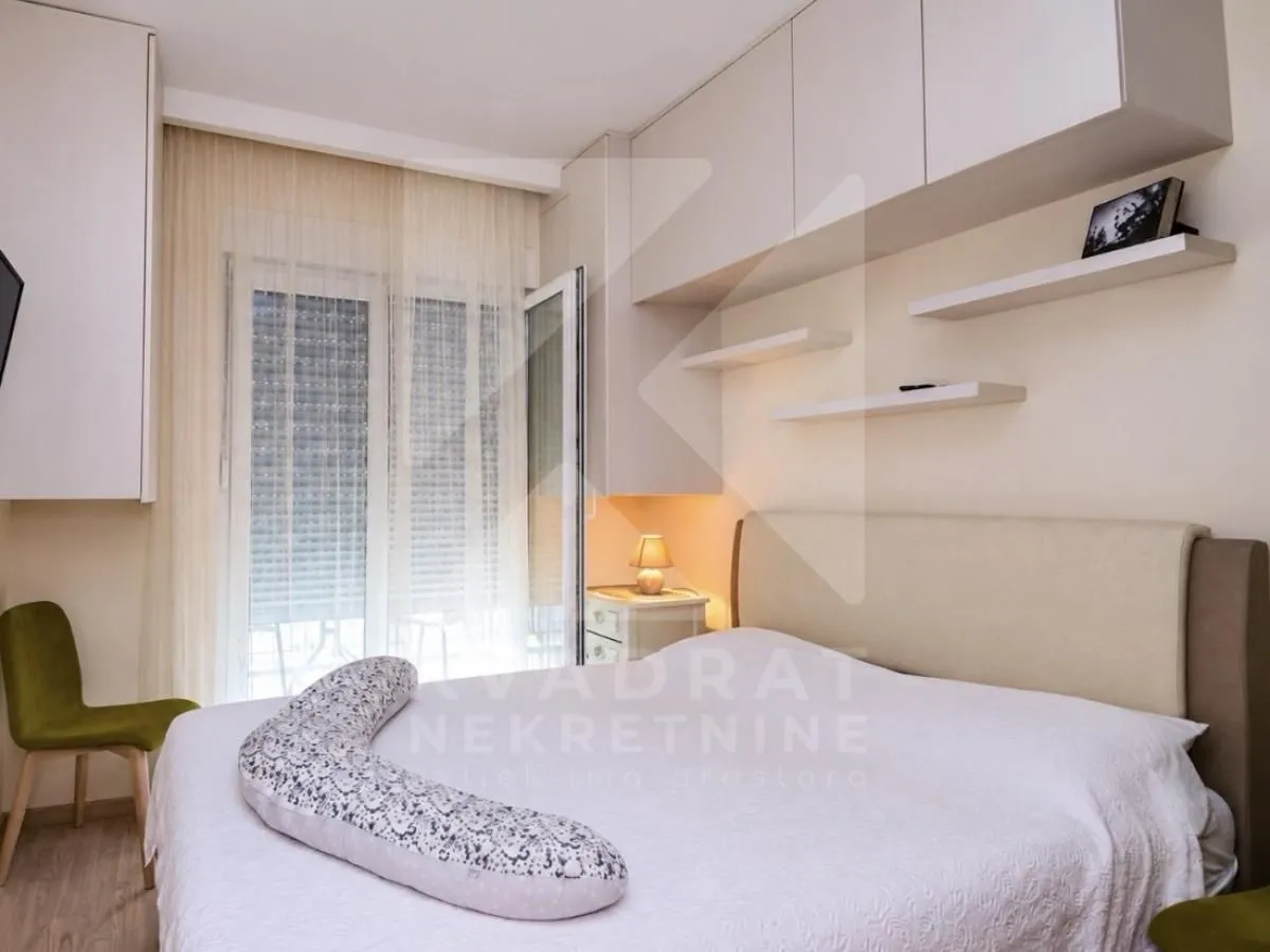 Cozy bedroom with a double bed, wall-mounted cabinets, and access to the terrace.
