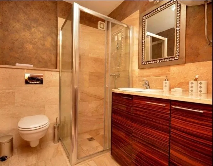 Moderno opremljeno kupatilo sa tuš kabinom, umivaonikom i wc šoljom.