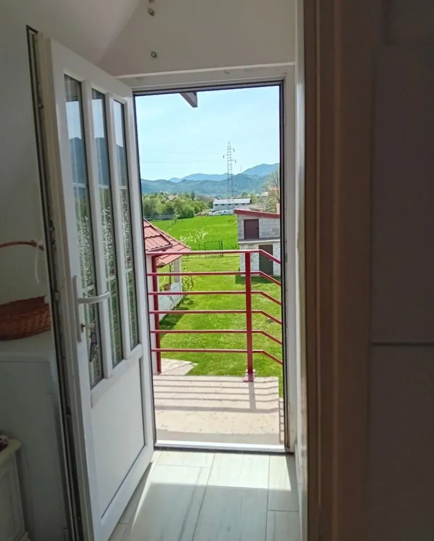 Pogled sa terase na zeleno dvorište i okolne planine.