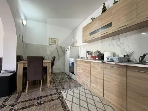 Kuhinja sa drvenim elementima i trpezarijskim stolom. - image 3