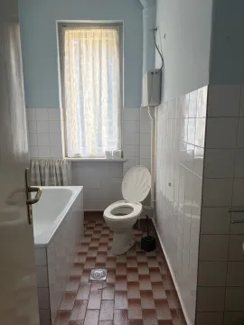 Manje kupatilo sa kadom, toaletom i prozorom. - image 5