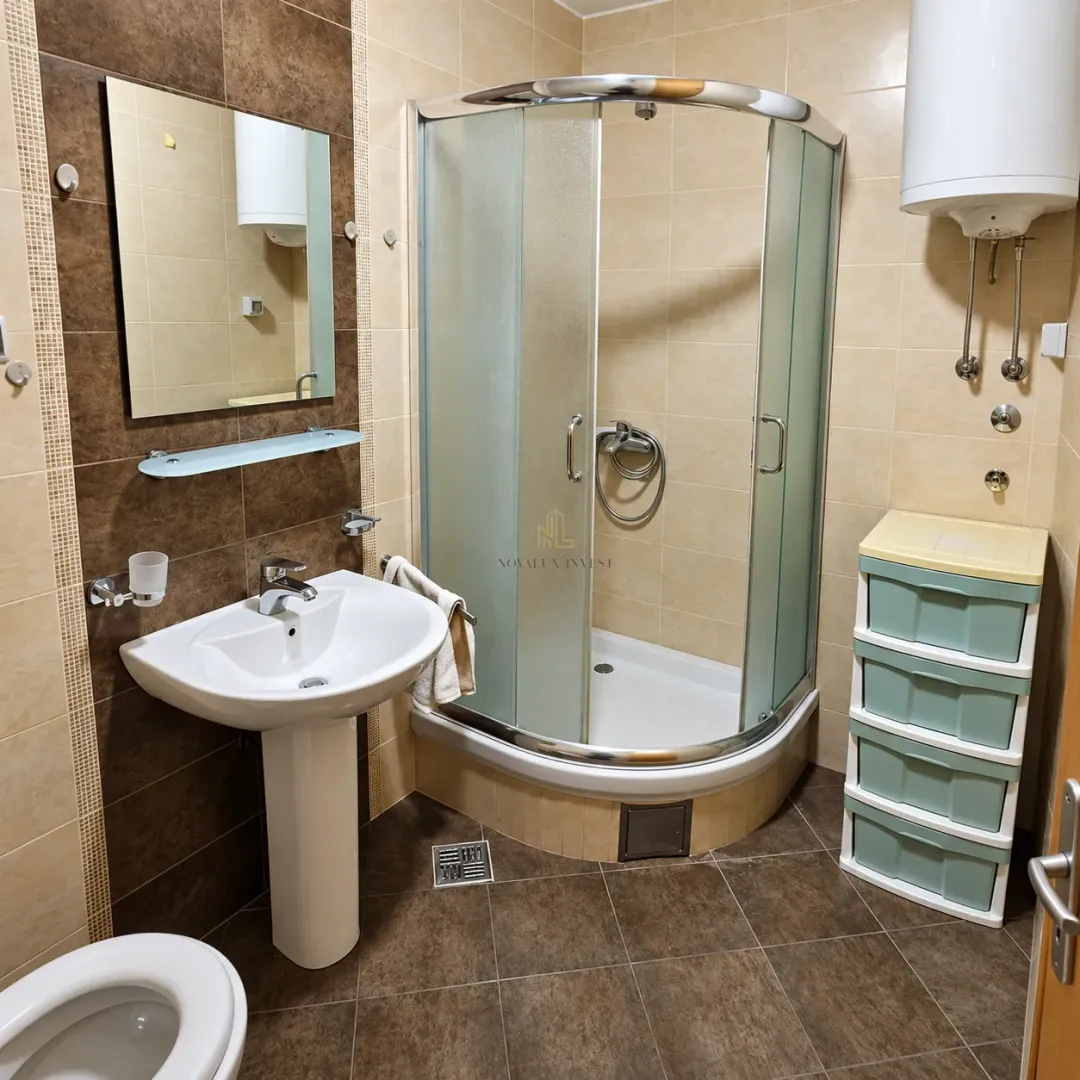 Kupatilo opremljeno umivaonikom, tuš kabinom i bojlerom.
