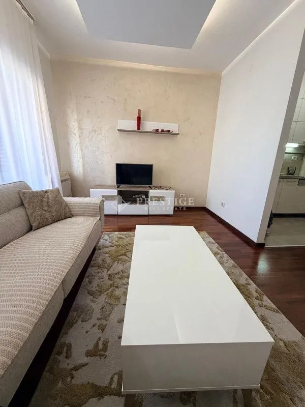 Dnevna soba sa garniturom, stočićem i TV komodom.