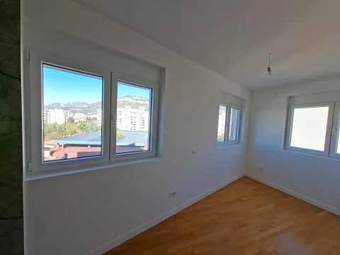 Empty room with hardwood floors, white walls, and a view through the windows. - image 6