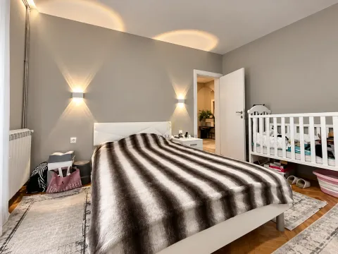 Namještena spavaća soba sa bračnim krevetom i krevetcem za bebe. - image 8