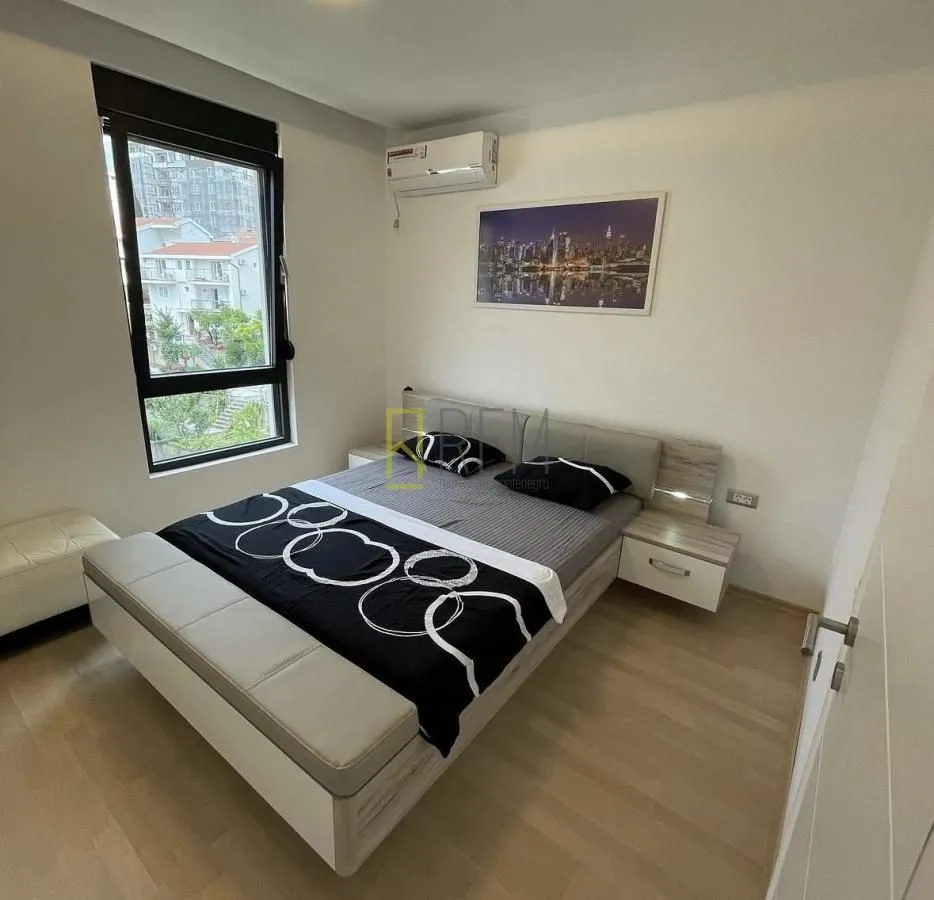 Furnished bedroom with a double bed, nightstands, and a window.